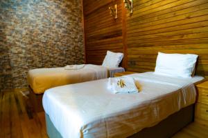 two beds in a room with wooden walls at HK Resort 