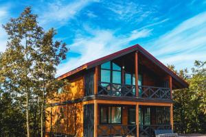 a wooden house with glass windows and a blue sky at HK Resort 