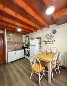 a kitchen and dining room with a table and chairs at Cabaña Mirador del Paraíso in Ushuaia