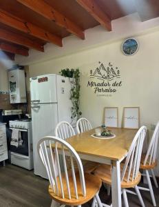 a kitchen with a table and chairs and a refrigerator at Cabaña Mirador del Paraíso in Ushuaia