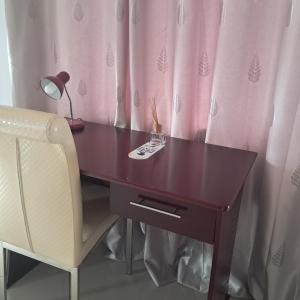 un bureau en bois avec une lampe et une chaise dans l'établissement Real Favour Suites Guest House, à Palatswe