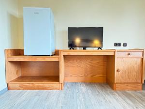 a room with a television on a wooden desk with a tv at 33 - 12 Hotelkamer voor twee personen in Bunkenburg