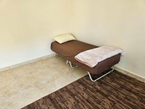 a small bed in a corner of a room at Rum Adventures Hostel in Wadi Rum