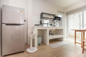 Japanese houses in Phuket في Ban Thalat Choeng Thale: غرفة بيضاء مع مكتب ومروحة