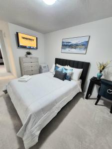 a bedroom with a large white bed in a room at First Class Ensuite Room in Brantford