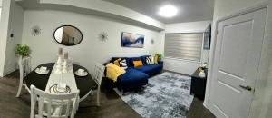 a living room with a blue couch and a table at First Class Ensuite Room in Brantford