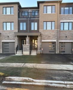a large brick building with a driveway in front of it at First Class Ensuite Room in Brantford