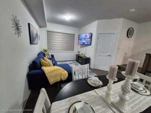 a living room with a blue couch and a table at First Class Ensuite Room in Brantford