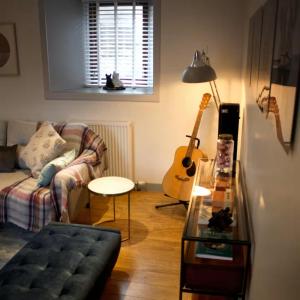 Aald Harbour Hoose في ليرويك: غرفة معيشة مع أريكة وجيتار +16 صورة