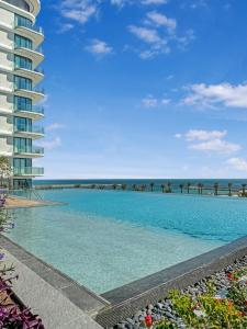 a large swimming pool next to a tall building at Marrasi Vista by the address in Muharraq +47 photos