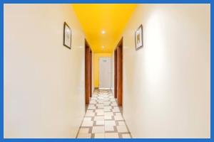 un couloir avec un plafond jaune et un sol carrelé dans l'établissement Hotel Kavyani Sidhant Palace Near Kashi Vishwanath Temple - Free Wifi and Free Parking Facilities - Free Wifi Facilities # Fully Air conditioning Luxuary Room - Top Rated Hotel In Varanasi, à Varanasi
