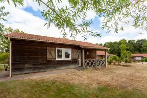 ein kleines Holzhaus mit einer Veranda auf einem Feld in der Unterkunft Un éco-camping en Vendée in Chauché