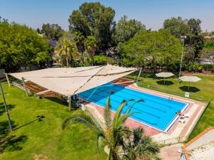 an overhead view of a swimming pool with a large umbrella at Eretz Zeelim in Ẕeʼelim