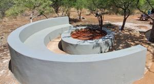 eine Feuerstelle aus Beton mitten in einem Park in der Unterkunft Zuri Camp - Tent Kiama in Tsumeb + 2 Fotos