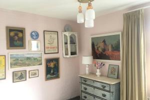 une chambre avec un mur orné de photos et une commode dans l'établissement Lovely Studio with Patio and Garden, à Westenschouwen