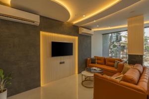 un soggiorno con un divano e una TV a parete di Hotel Shree Narayana By Perfectstayz Group a Ujjain