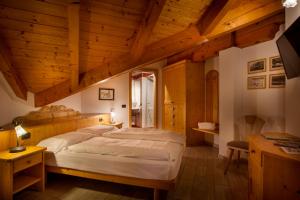 um quarto com uma cama grande em um quarto com teto de madeira em Agritur Bontempelli em Pellizzano