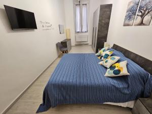 a bedroom with a bed with blue sheets and pillows at Al Vecchio Orologio in Viterbo