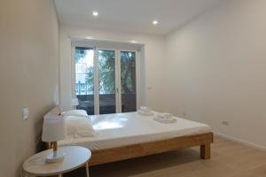 Una habitación blanca con una cama y una ventana en EUR Suites, en Roma