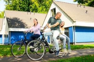 a man and two women sitting on a bike at Walibi Village in Biddinghuizen