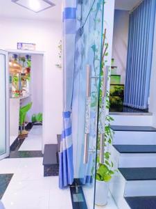 Un pasillo con escaleras azules y blancas con plantas. en Hoàng Nga Apartment Phan Thiết, en Phan Thiet