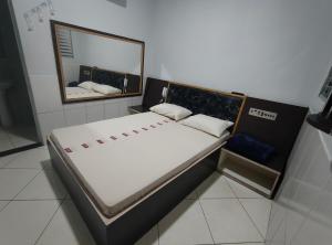 a bed in a room with a mirror at Hotel Flert Santana in Sao Paulo