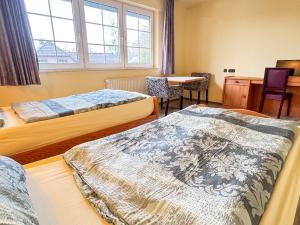 a room with two beds and a table and a desk at 33 - 13 Hotelkamer voor twee personen in Bunkenburg
