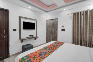a bedroom with a bed and a flat screen tv at FabHotel Yatri Nivas - Assi Ghat in Varanasi