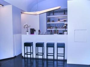 a bar with four black stools in a room at Culture Hotel Centro Storico in Naples