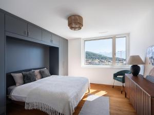 Un dormitorio con una cama grande y una ventana en Exclusive SKY Penthouse in Thun, en Thun