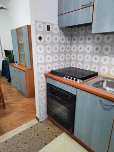 eine Küche mit Herd und Spüle in der Unterkunft Vittorio Emanuele Central Apartment in Letojanni + 31 Fotos