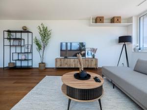 Una sala de estar con un sofá y una mesa de café. en Exclusive SKY Penthouse in Thun, en Thun
