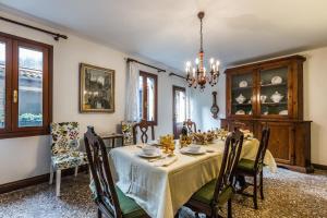 comedor con mesa, sillas y lámpara de araña en Ca' Affresco 2, en Venecia