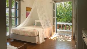 a bedroom with a bed with a mosquito net at Beachfront Family Villa in Eretria