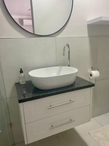 a bathroom with a white sink and a mirror at Stellenbosch Serenity in Stellenbosch +3 photos