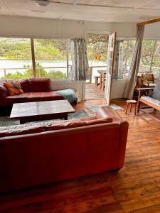 un salon avec deux canapés et une table dans l'établissement Explore River Cottage Ocean View, à Seafield