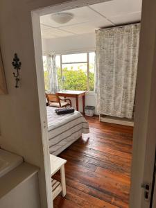 une chambre avec un lit, une table et une fenêtre dans l'établissement Explore River Cottage Ocean View, à Seafield