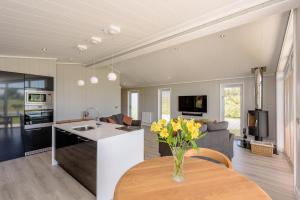 a kitchen and living room with a vase of flowers on a table at Landal North Lakes in Brayton Station +10 photos
