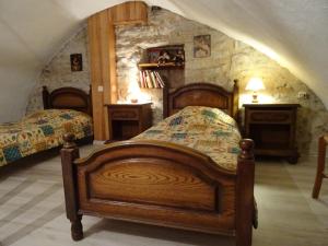 Un dormitorio con dos camas y una pared de piedra. en La Maison du Berger, en La Cresse 5 fotos más