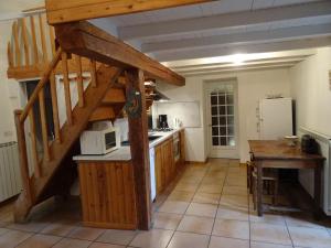 una cocina con una escalera que conduce a un loft en La Maison du Berger, en La Cresse