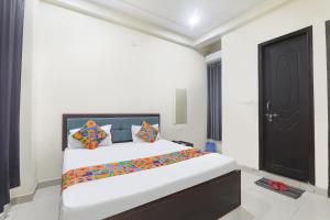 um quarto com uma cama e uma porta preta em FabHotel JP International em Lucknow mais 14 fotografias