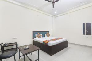 um quarto com uma cama, uma mesa e cadeiras em FabHotel JP International em Lucknow