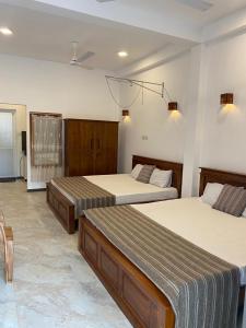 two beds in a hotel room with two beds at Grindlays Villa in Weligama