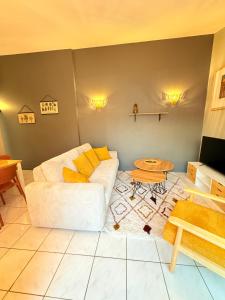 ein Wohnzimmer mit einer weißen Couch und einem Tisch in der Unterkunft Le Palais in La Rochelle