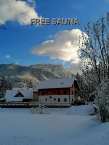 a train station in the snow with the words free sauna at Apartments Gorski raj in Kranjska Gora