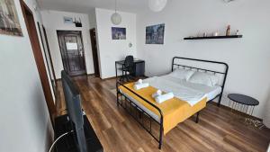 a bedroom with a bed and a flat screen tv at Luca Apartament in Bucharest