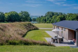 a building with a bench and an umbrella next to a field at Landal North Lakes in Brayton Station