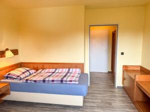 a bedroom with a bed with a plaid blanket on it at 33 - 14 Hotelkamer voor twee personen in Bunkenburg