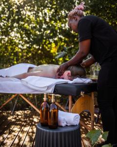 阿马卡拉保护区Induli Lodge - Amakhala Game Reserve的一名女子与一名男子躺在床上