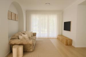 a living room with a couch and a television at Creekside Manor - Spacious | Nature & Serenity - Holiday Home in Gold Coast